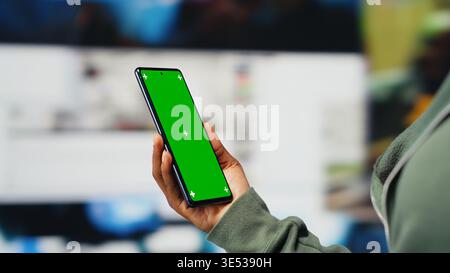 Isolated screen smartphone used by person entertained by clips, enjoying tech bridging people worldwide. Woman uses mockup mobile phone to look at videos, enjoying digital age life, camera B closeup Stock Photo