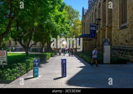 Students walking through University of Adelaide campus beside historic sandstone building, Adelaide, South Australia Stock Photo