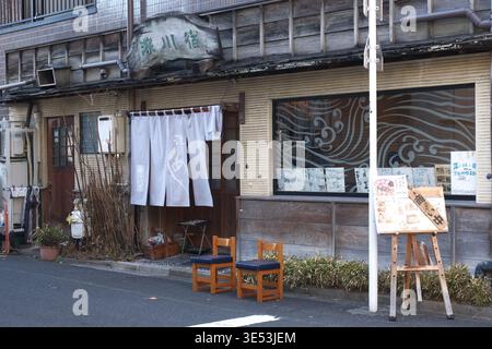 Traditional Japanese restaurant Fukagawa-juku in Tokyo, featuring a wooden facade, Noren curtains, and rustic signage Stock Photo