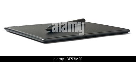 black digital stylus pen on graphics tablet surface isolated white background, dotted texture on tablet face, low angle view Stock Photo