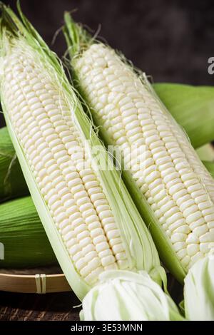 Fresh sweet corn ears presenting raw white kernels Stock Photo