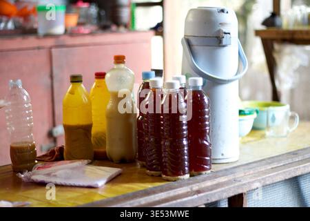 Homemade jamu bottles on table in Yogyakarta, Indonesia, showing traditional herbal drinks and local preparation. Stock Photo
