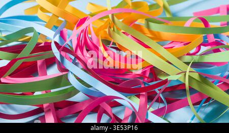 Paper ribbons arranged randomly forming a vibrant and multi-colored tangle Stock Photo