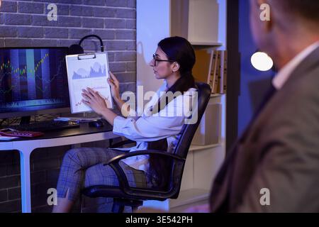 Business analysts working with diagrams in office at night. Data science concept Stock Photo