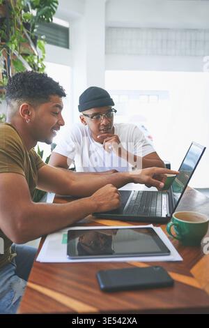 Team, research and men with laptop in coffee shop, thinking and planning for design on web or online. Cafe, logo designer and people with tech for Stock Photo