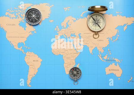 Different modern compasses on world map as background Stock Photo