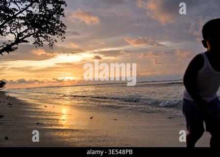 Dramatic Golden Sunset Over the Beach with Glowing Yellow Sky Stock Photo