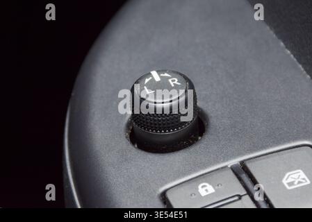 Car Side Mirror Control Switch, A close-up of a black textured rotary switch for electronic side mirror adjustment, showing L and R positions on a car Stock Photo