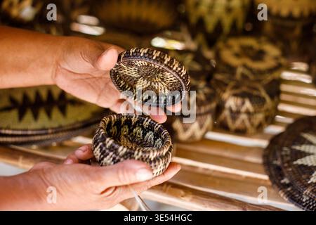 Village market stall displaying handmade bamboo crafts and woven baskets outdoors. Stock Photo