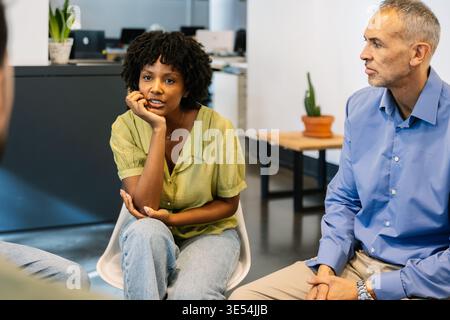 Business professionals discussing work solutions in an office meeting Stock Photo