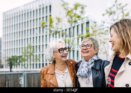 Group of three senior women enjoying urban friendship laughing together Stock Photo