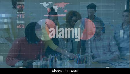 Collaborating team of eight in casual attire leaning over office table, pointing at tablet, papers Stock Photo