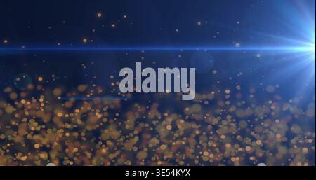 Glittering cluster of golden bokeh particles filling navy-blue field, with cool-blue lens flare Stock Photo