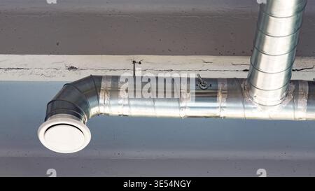 Metal duct system on a ceiling in an industrial building during daylight hours Stock Photo