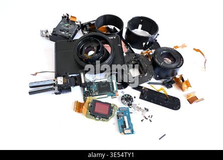 Disassembled Sony RX100 digital compact camera showing internal components including lens, sensor and circuit boards during repair process Stock Photo