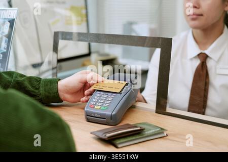 Caucasian Young Adult Man Making Payment with Credit Card at Bank Branch Counter Stock Photo