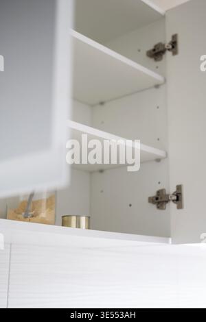 Bright minimalist kitchen cabinet with open empty shelves and simple food storage containers. Clean and modern home interior concept, everyday domesti Stock Photo
