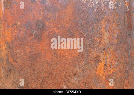 Textured rusted metal sheet displaying warm orange patina, subtle granular corrosion, mottled surface, weathered aesthetic, vintage backdrop for desig Stock Photo