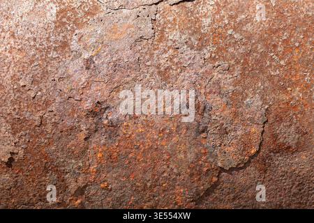Metal rust appearance. Weathered metal featuring vibrant orange and red hues. Surface of metal showing extensive rust with rich patina and cracks Stock Photo