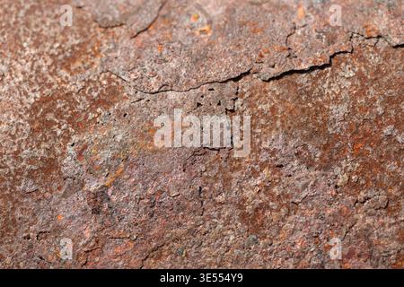 Macro rust on metal crack revealing layered flake and rough oxidation, deep fissure and varied tones create dramatic textured closeup for repair and d Stock Photo