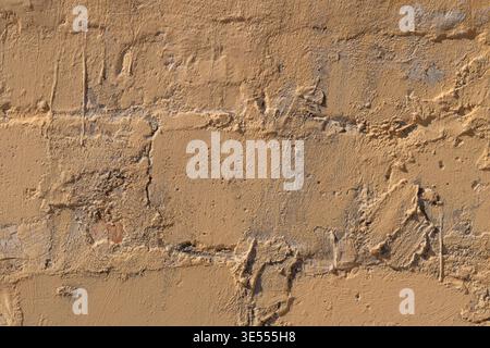 Warm sandy brick wall closeup revealing granular texture, weathered mortar, tan tones, subtle erosion lines, rugged rustic mood, ideal for backdrop in Stock Photo