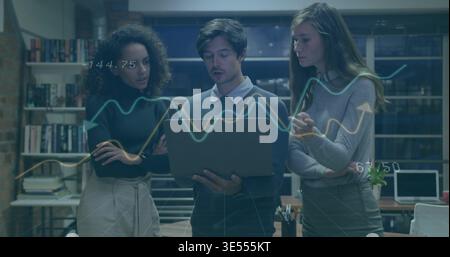 Analyzing three coworkers in office attire examining laptop in meeting area with line graph overlay Stock Photo