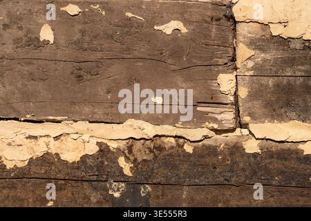 Weathered wooden boards with peeling paint, deep cracks and rough grain, aged patina and warm sepia tones, rustic decay mood, ideal for vintage editor Stock Photo