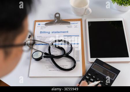 Overhead view of healthcare billing statement with stethoscope, tablet, calculator and doctor reviewing costs, representing medical finance, insurance Stock Photo