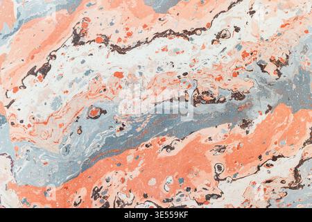 Soft coral and muted blue marbling forms an abstract texture with flowing swirls, speckles and layered tones, perfect for backgrounds, packaging, inte Stock Photo