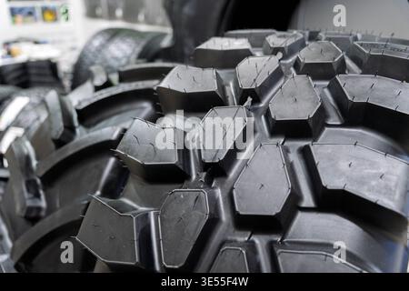 Close-up of a rubber tire tread for agricultural or off-road machinery on display at a trade exhibition, featuring deep hexagonal lugs designed for Stock Photo