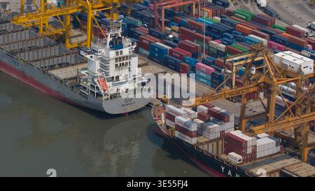 Bangkok, Thailand - 05 February 2026: Aerial view of Bangkok Port with large container ships, yellow gantry cranes, and stacks of colorful shipping co Stock Photo