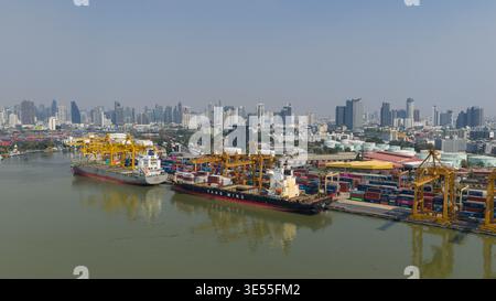 Bangkok, Thailand - 05 February 2026: Aerial view of Bangkok Port featuring large container ships docked at the terminal with yellow industrial cranes Stock Photo