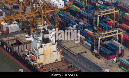 Bangkok, Thailand - 05 February 2026: Aerial view of Bangkok Port with a large container ship docked next to stacks of multicolored cargo containers a Stock Photo