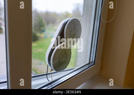 Automatic Robotic Window Cleaner Working on a Glass Surface Stock Photo