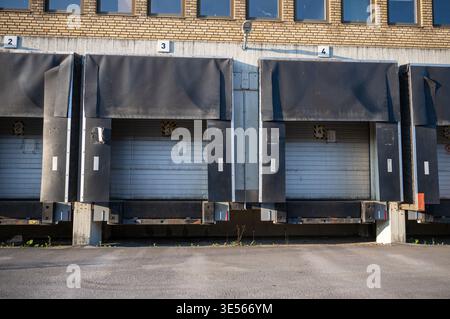 Industrial warehouse loading docks with truck bays logistics distribution center exterior commercial building Stock Photo