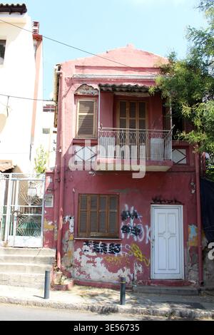 Old pink house Ano Poli August 2024 Peeling paint and street art on facade Stock Photo