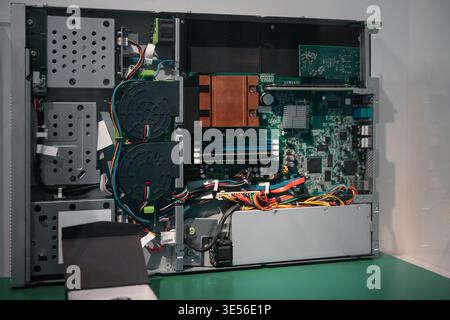Opened classic server internals. A detailed interior view of an older server unit: motherboard, copper heatsinks, and dual rack-mounted cooling fans. Stock Photo