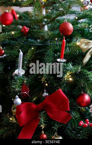 A beautifully decorated Christmas tree with red bows, berries and glowing lights. Stock Photo