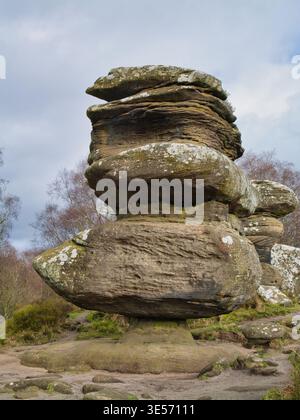 Yorkshire, UK - Mar 16 2026: Weathered balancing stones rise at Brimham Rocks in Yorkshire UK, creating a dramatic natural landmark under a bright cloud filled sky Stock Photo