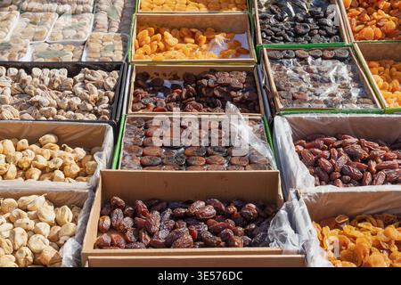 Assorted dried fruits in boxes at market dates apricots figs natural healthy food assortment display Stock Photo