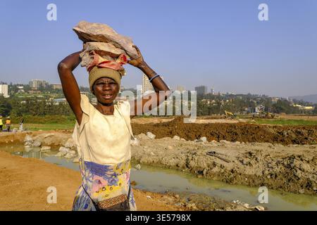 Worker carrying blocks on construction site in Kigali, Rwanda Stock Photo