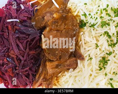 A close-up overhead view of a plated meal featuring three distinct components arranged side by side. On the left portion is shredded red cabbage with Stock Photo