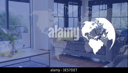 Displaying dotted world map overlay and white globe spanning modern living room with gray sofa Stock Photo