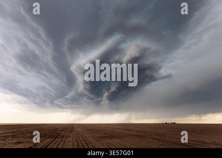 Dark storm clouds from a supercell over a field Stock Photo