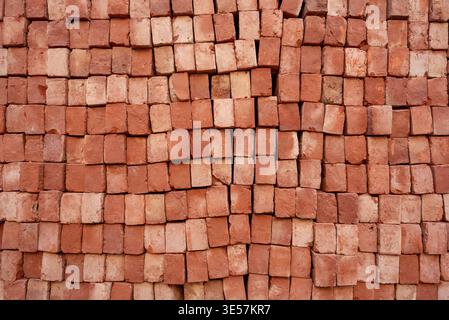 Stack of red bricks arranged end-on, close-up texture background for construction industry Stock Photo