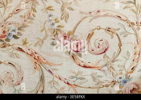 Soft pastel floral tapestry fabric with ornate rose scrolls and delicate vines, evoking vintage elegance and romantic charm. Textured textile detail i Stock Photo