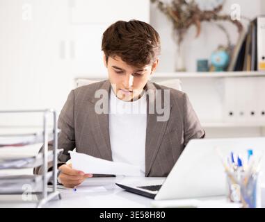 Businessman works in the office - puts documents in order and draws up contract Stock Photo