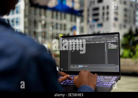 Writing code, laptop closeup and software developer on park bench implementing algorithms. freelancing outdoors, notebook display and programmer using programming languages script program Stock Photo