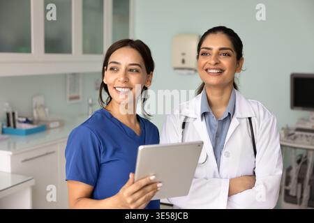 Two women doctors look into distance with contented, optimistic smile Stock Photo
