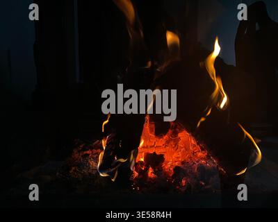 Glowing Embers On Burning Log, Orange Flame Licking Charred Wood, Smoky Warmth And Soft Crackle, Night Cabin Stock Photo